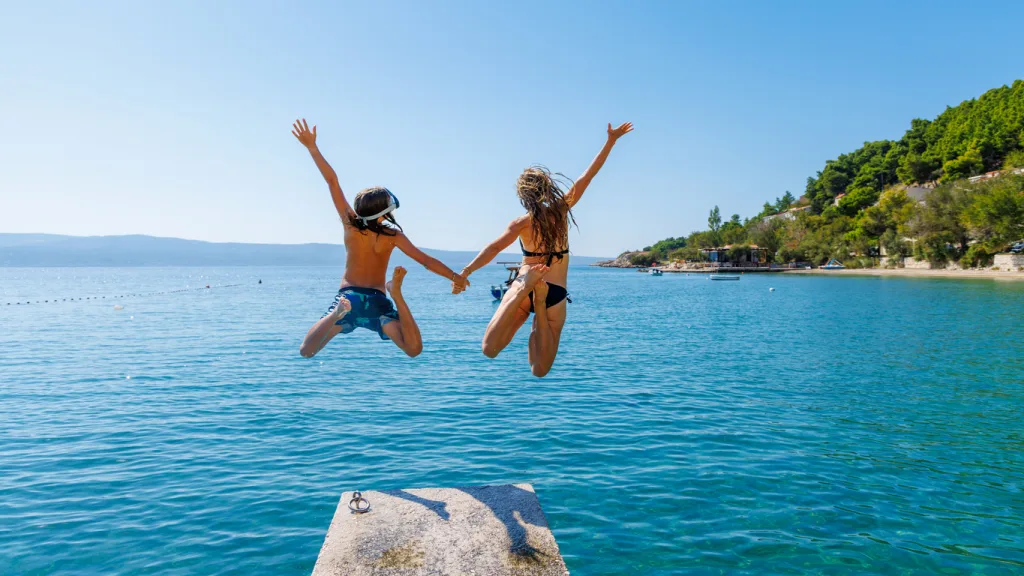 Jumping into water- vacation,travel, fun on summer day- family, friends