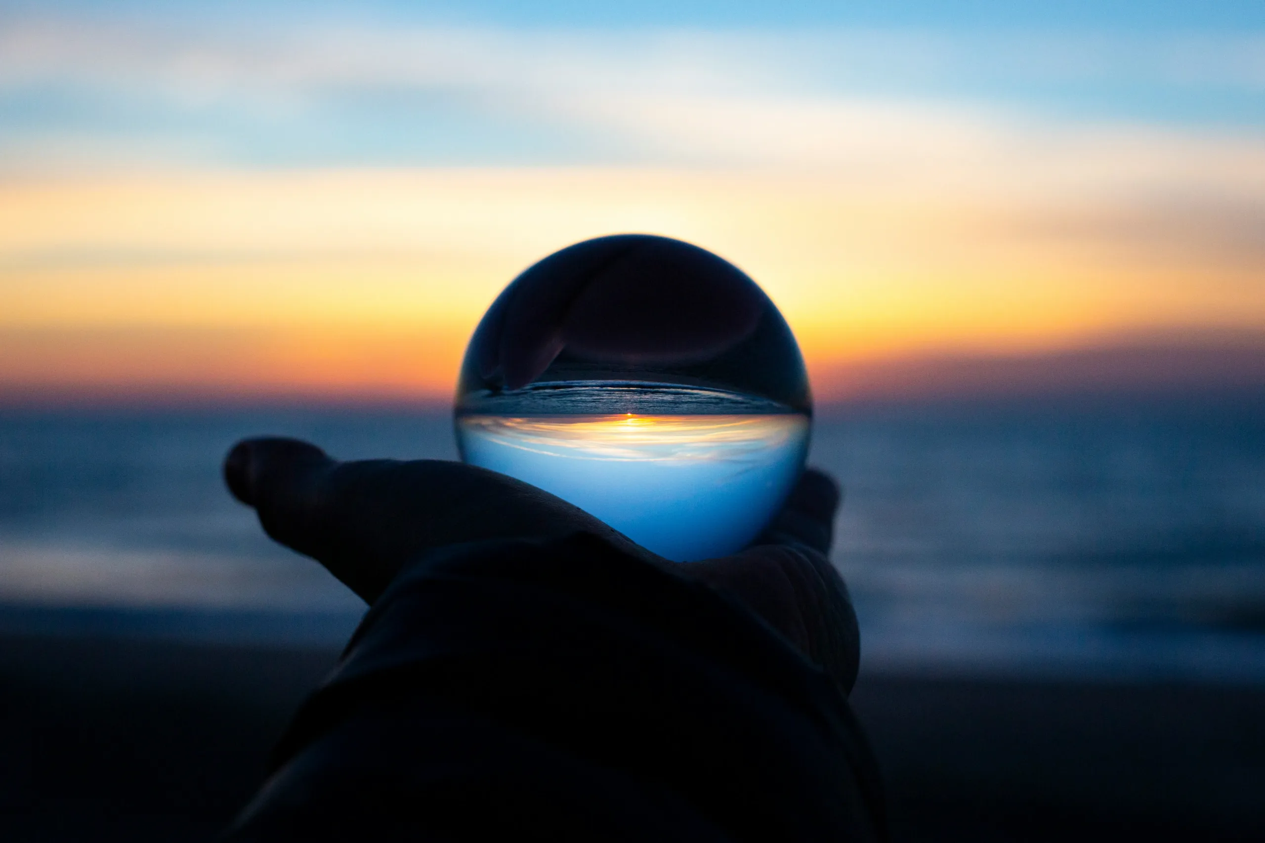 Vision of sunset over sea through crystal ball