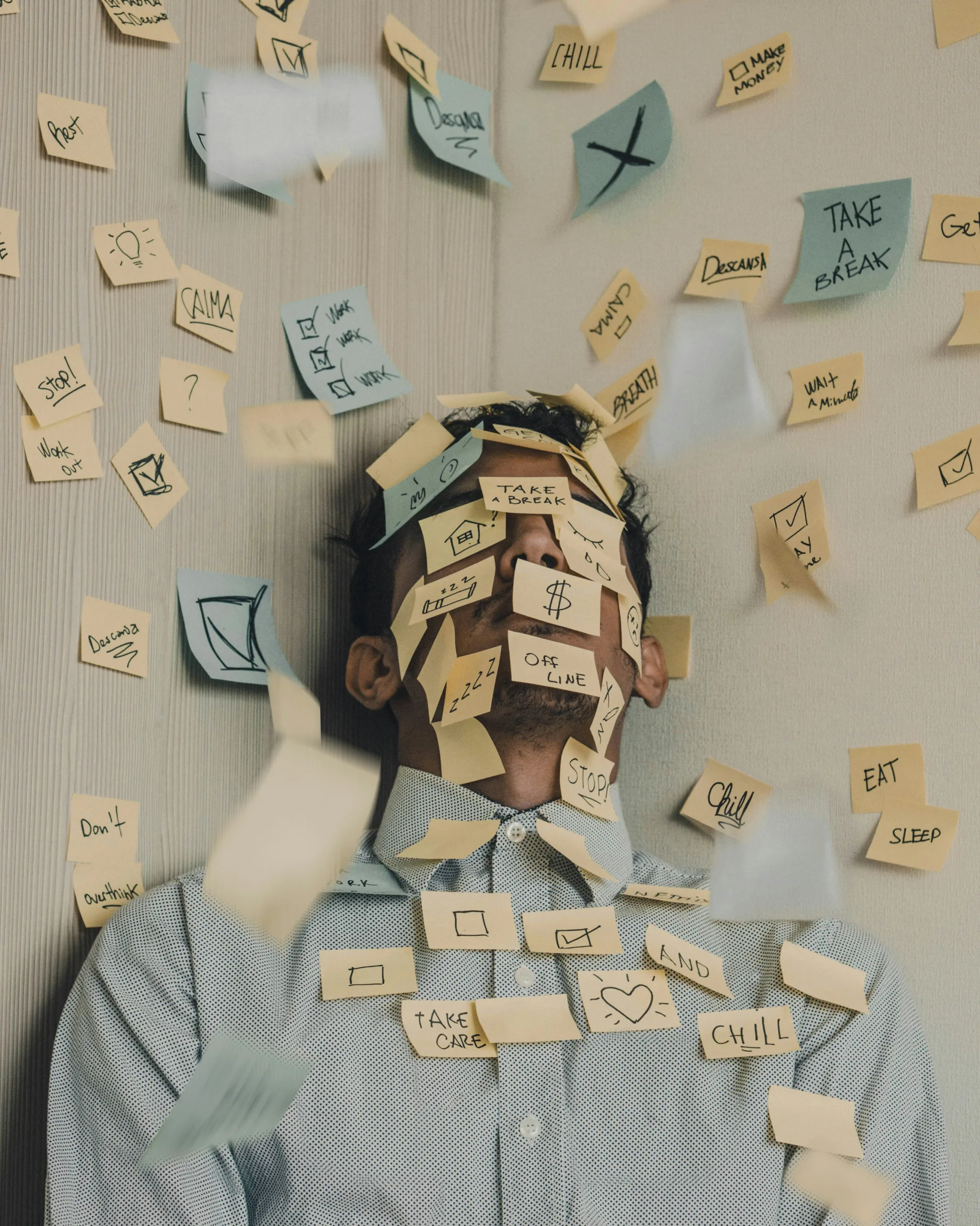 Man overwhelmed with Post-It notes all over his face. He needs Rachel Bamber's Executive Coaching!